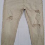 A pair of beige distressed denim jeans with ripped details and a worn-in look.