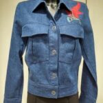 Dark blue denim jacket with button closure and red floral embroidery on the chest.